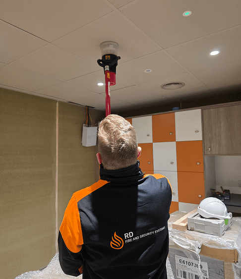 team member installing a fire alarm