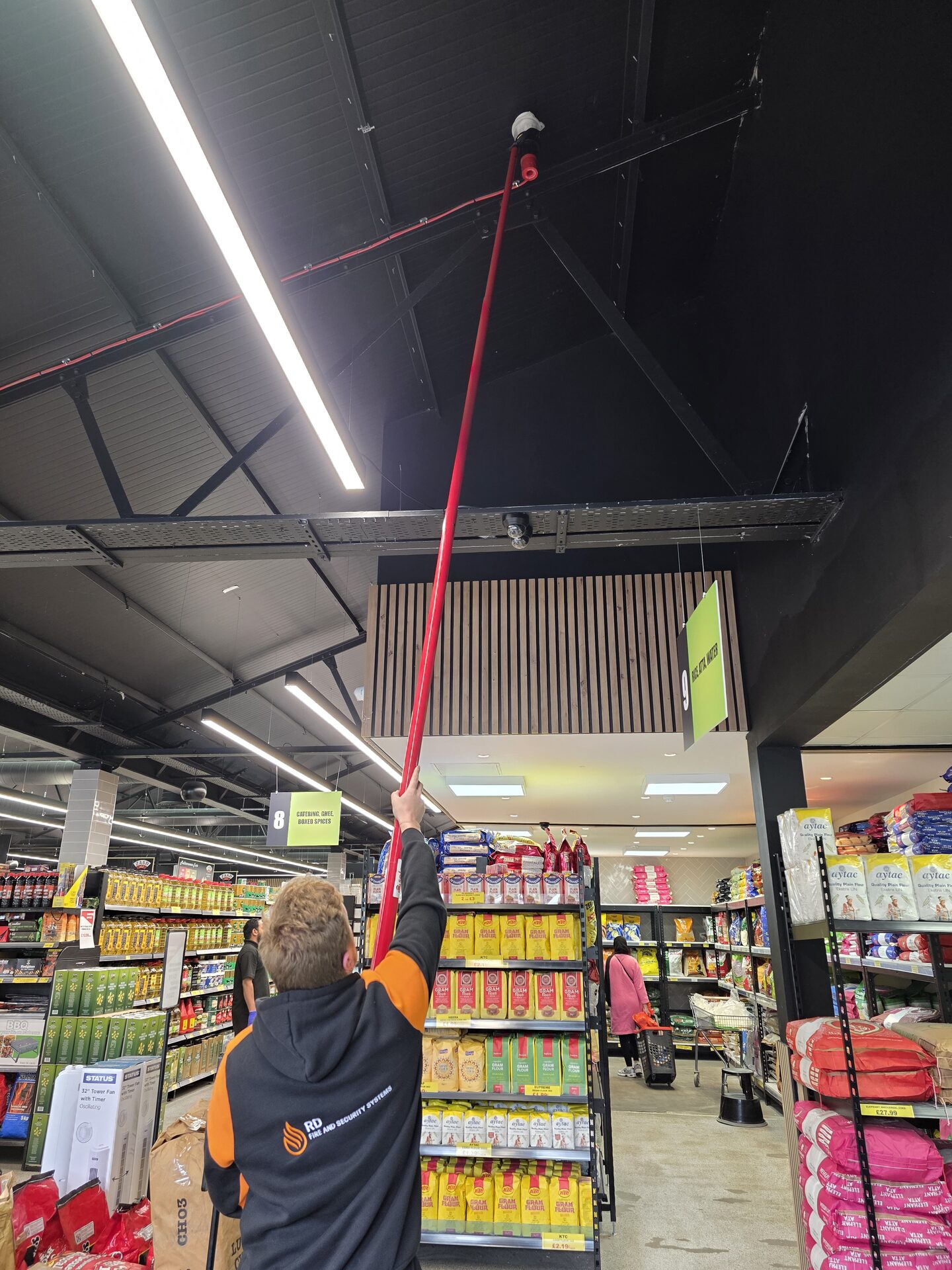 engineer installing a fire alarm system in a commercial store
